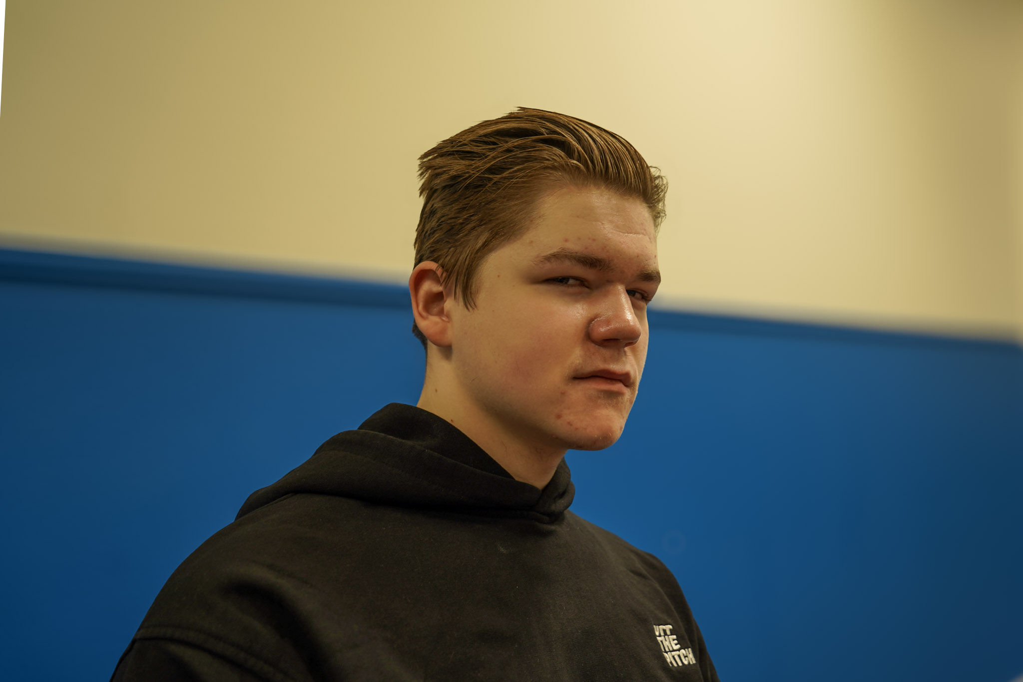 Portret van een jongeman voor een blauwe muur