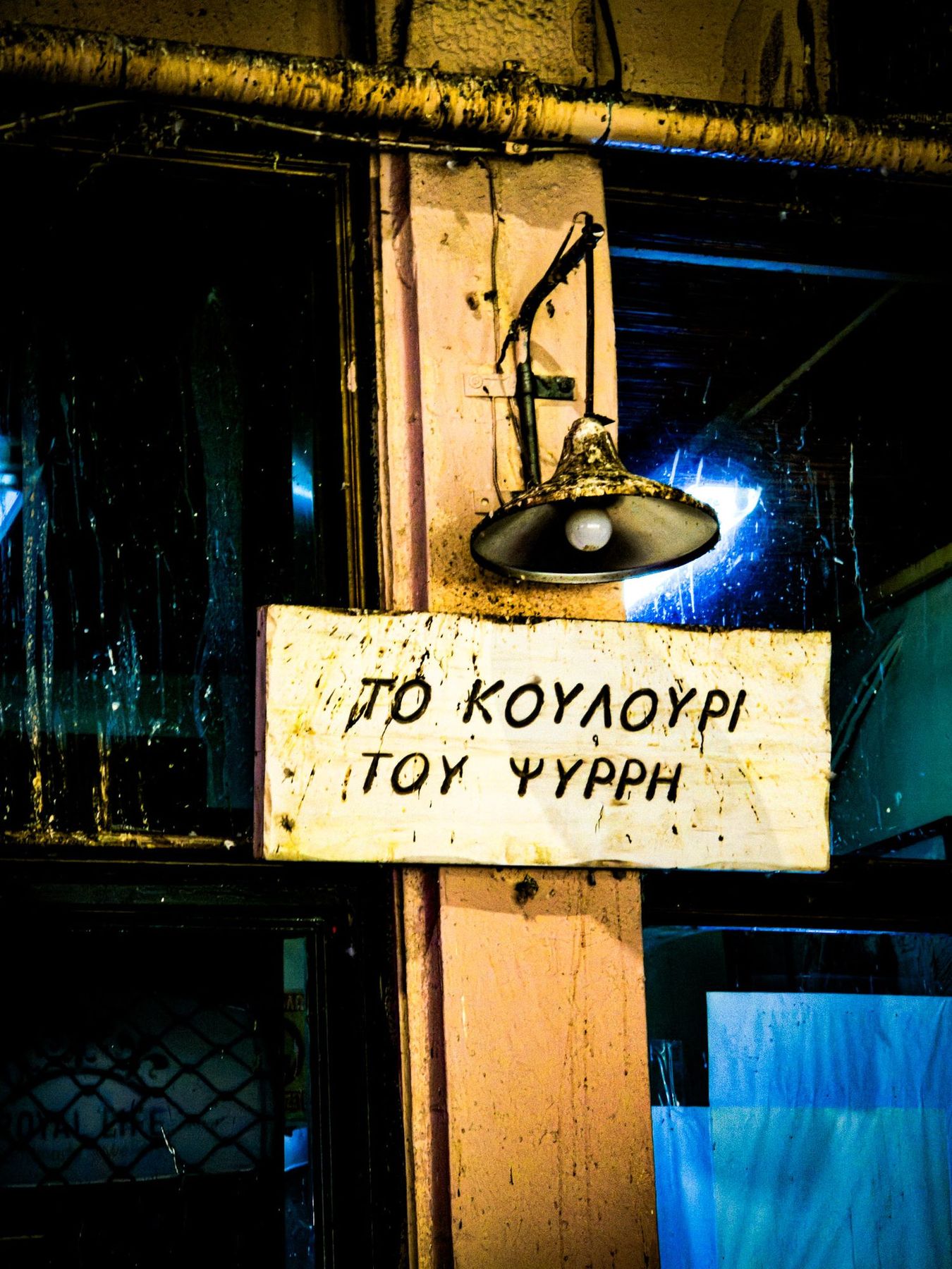 Oud Grieks bord met lamp aan een gevel in Athene